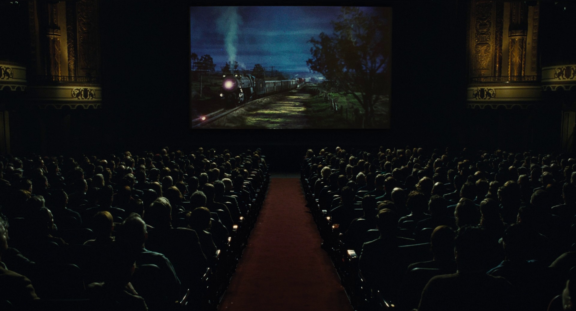 a movie frame from The Fablemans shows a large audience watching a film showing a steam train.